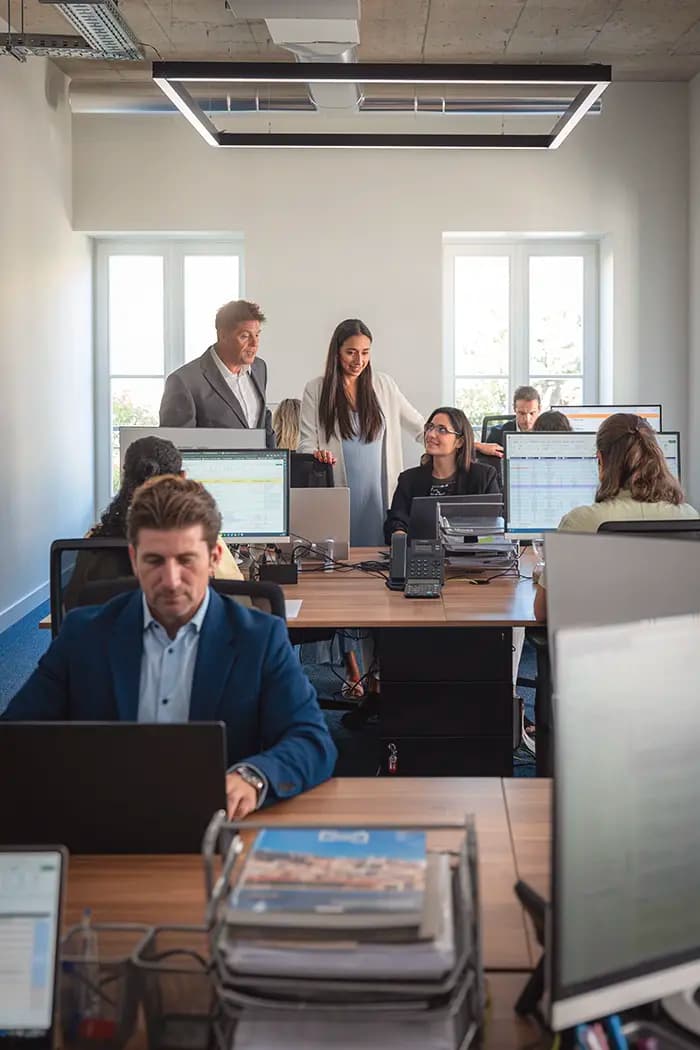 Open office workspace with Harland & Poston Group team members collaborating on projects.