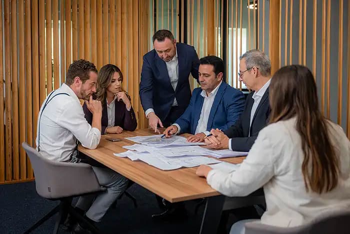 Architects and project managers reviewing real estate blueprints during a meeting