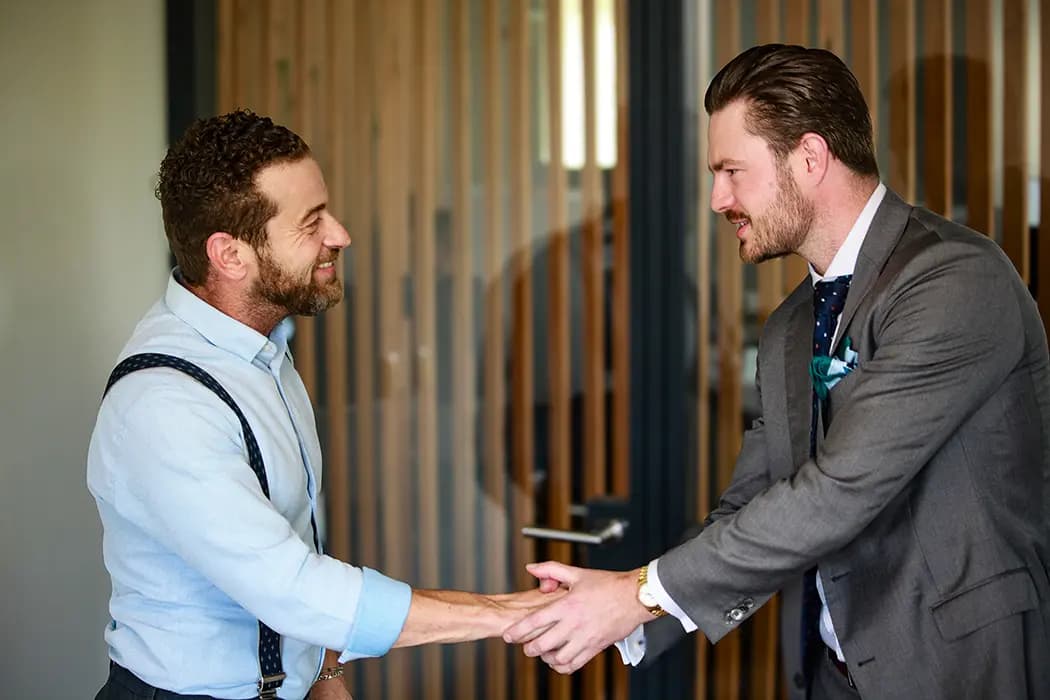 A businessman and a property advisor exchanging a handshake at Portugal Homes' Lisbon branch.