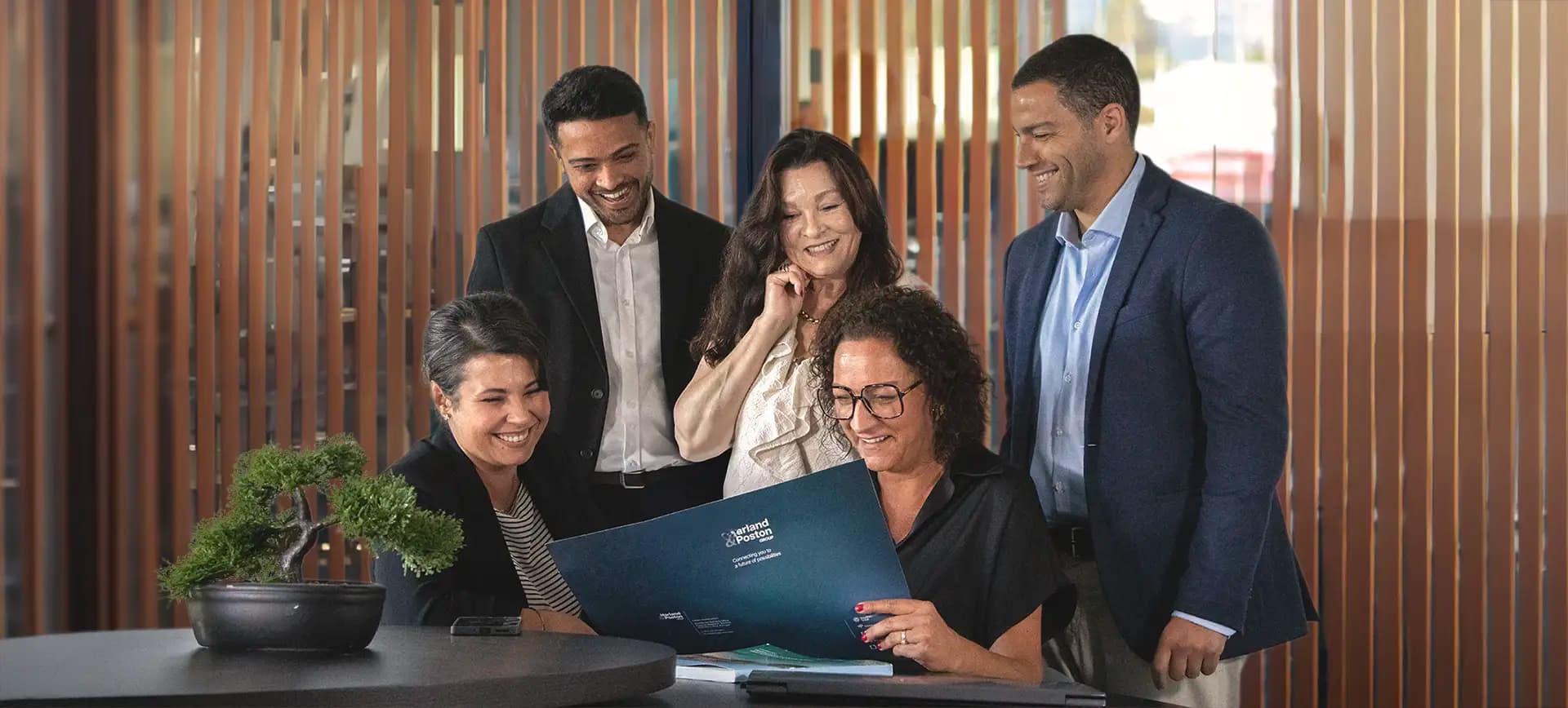 Harland & Poston Group team collaborating in a modern office environment