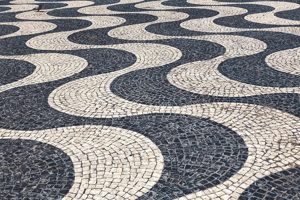 Pavement of the Rossio square in Lisbon, a striking "mar largo" (wide sea) of undulating black basalt and white limestone waves that pay homage to Portugal's maritime history.