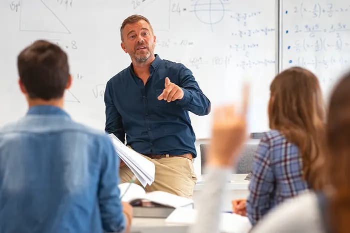 Teacher leading a maths lesson with equations on the whiteboard and students participating